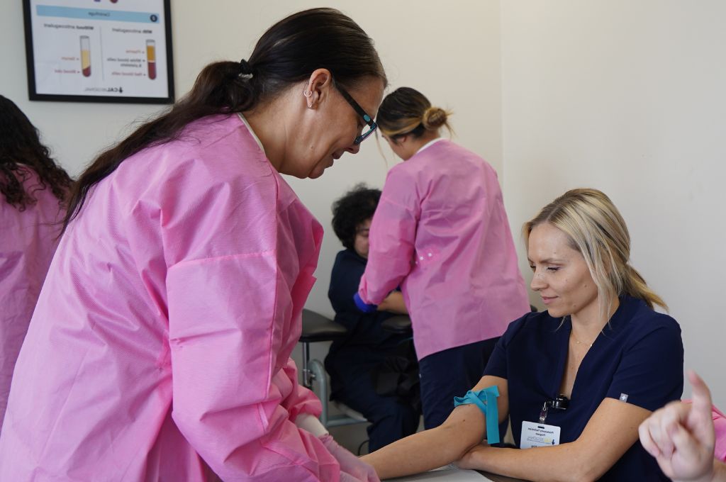 Phlebotomy students practicing venipuncture in a California-based vocational school program