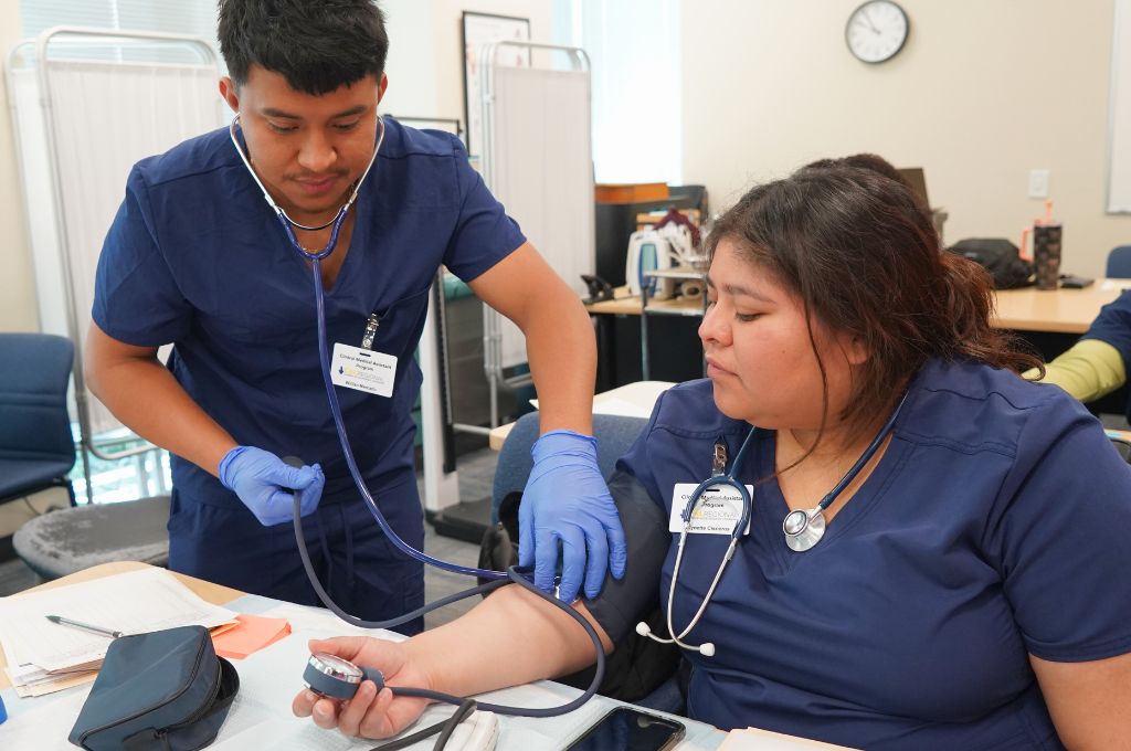 Medical assistant student in Monterey practicing blood pressure skills during hands-on training.