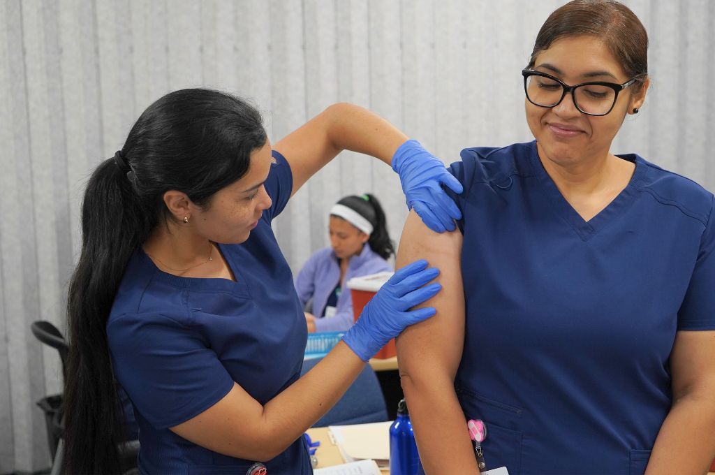 Medical assistant student practicing injection technique as part of clinical skills training.